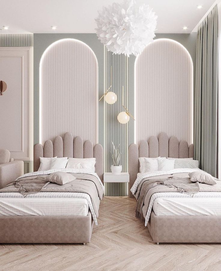 Modern twin bedroom with plush scalloped beige headboards, white and neutral bedding, floating nightstand with plant, pendant lights, arched alcove wall design, chandelier, herringbone wood flooring, and muted green curtains